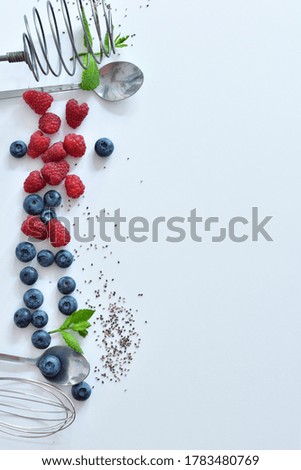 Summer layout made with juicy ripe berries of blueberries and raspberries on a white background.Summer mood. Copy space. Selective focus. Flat lay