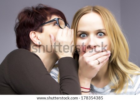 two women sharing a secret Royalty-Free Stock Photo #178354385