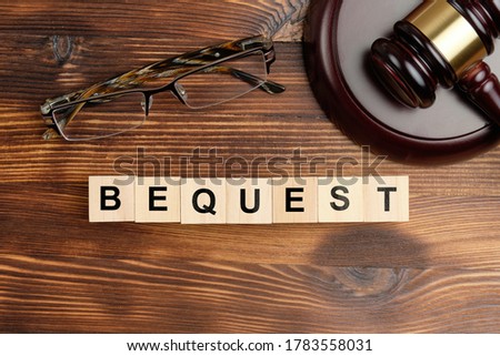 Bequest concept on wooden cubes next to the judge hammer. Royalty-Free Stock Photo #1783558031
