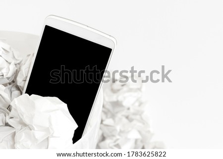 A smartphone thrown in the trash. Image of digital detox