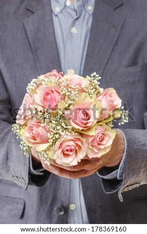 Man holding bouquet of pink roses