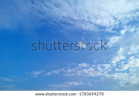 On a bright sunny day in the silver blue sky with white gray clouds floating in the air beautifully. The background is a blue sky Is a picture of clouds in the sky in beautiful nature