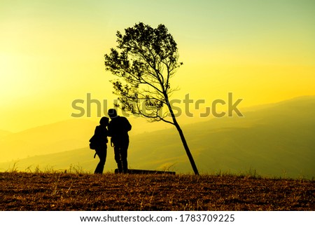 silhouette of Lovers stand and watch the sunrise in the morning