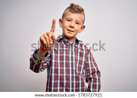 Young little caucasian kid with blue eyes wearing elegant shirt standing over isolated background pointing finger up with successful idea. Exited and happy. Number one.