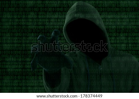 Internet theft - a hooded man grabbing a binary code