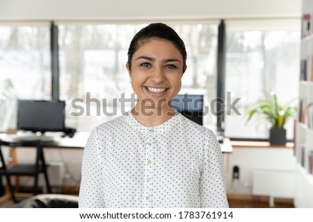 Headshot portrait of smiling indian female employee look at camera pose in office, profile picture of happy millennial biracial woman worker show confidence success at workplace, leadership concept