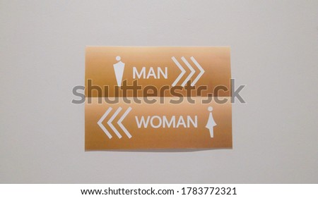 A men and women toilet sign on the wall. Direction sign.