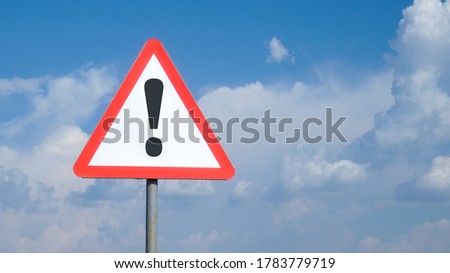 Exclamation mark on road sign background sky with clouds, warning, danger, attention