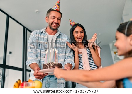 Happy Birthday! Beautiful mother and handsome father with their daughter and son spending time together at home and celebrating Birthday. Happy family concept.