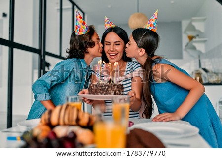 Happy Birthday! Beautiful mother and handsome father with their daughter and son spending time together at home and celebrating Birthday. Happy family concept.