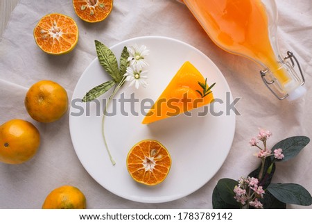 Orange sherbet layer cake top with slice orange and orange juice