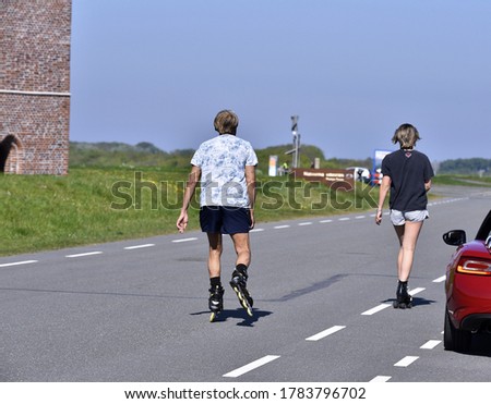 a couple rollerskating on the road