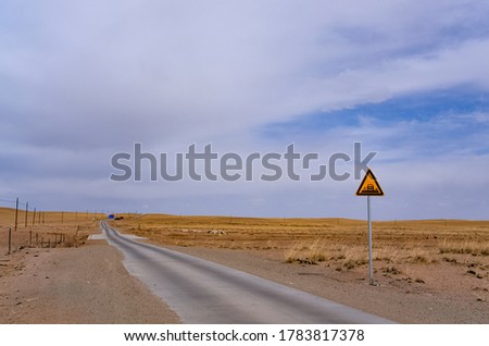 Road on the grassland, under the blue sky