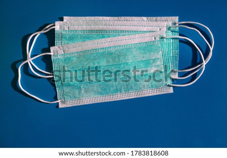 Medical protective green masks activated carbon disposable fiber face on blue background. Face masks that covers mouth and nose, that protects against virus, flu, coronavirus (COVID-19), bacterial.