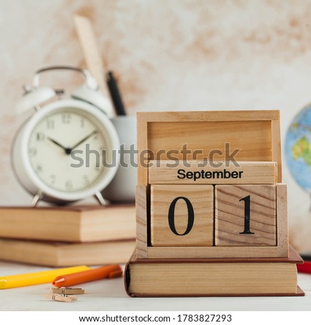 Wooden calendar September 1 on book, globe, alarm clock. Concept for Knowledge Day, beginning of school year. Copy space