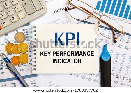 Office desktop - photo from above. Caption - KPI Key performance indicator. Idea, evaluation.