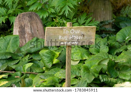 Rustic wooden signpost to bug hotel. Concept of helping create better natural environment