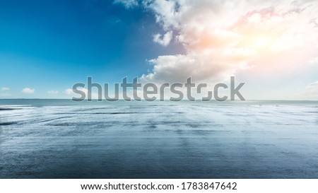 Asphalt square and lake under blue sky after rain. Royalty-Free Stock Photo #1783847642