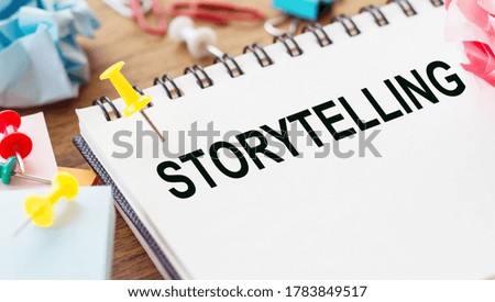 The word STORYTELLING on notebook and wooden desk background. Business Concept