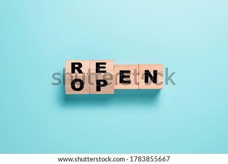 Reopen wording parting screen on wooden cubes block. Shopping mall and restaurants open again after COVID 19.