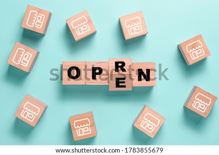 Reopen wording parting screen on wooden cubes block among illustration shop. Shopping mall and restaurants open again after COVID 19.