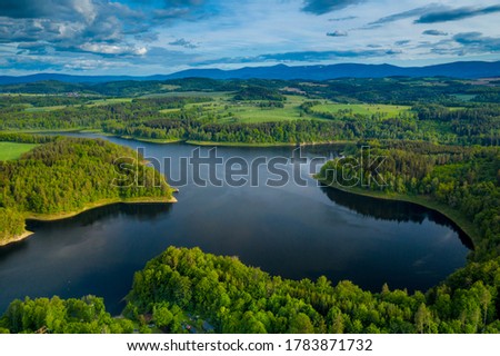 Aerial view of beautiful lake with islands and green forests near Karkonosze Mountains on a sunny summer day in Pilchowice, Lower Silesia, Poland. Drone photography