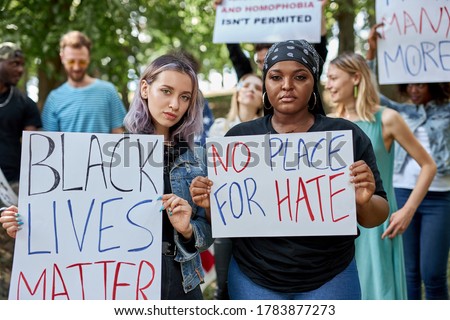 Black Lives Matters protesters or activists in holding signs and marching outside. diverse people demonstrate their dissatisfaction with situation in America connected with killing black people