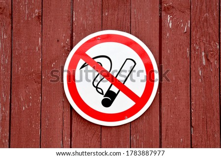 No smoking circular information sign on a wooden wall background