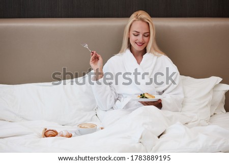 young lady have meal on after waking up in hotel, blonde lady have rest, relax, spend weekends in luxurious hotel