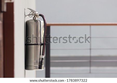 Fire extinguisher in the operating department . Install a fire extinguisher on the wall in building. Dry chemical powder fire extinguisher in corridor .a red fire-extinguisher hangs on wall .