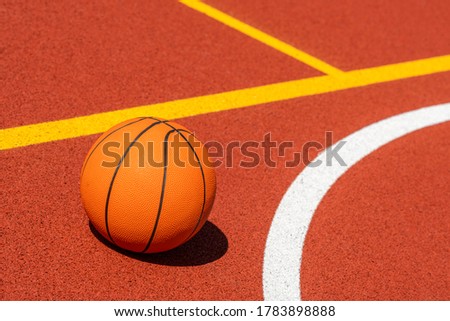 Basketball ball in the outdoors court on sunny day
