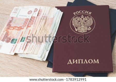 diploma of higher education of Russia on the table and cash notes, inscription in Russian, translation: "Russia, Diploma", the concept of higher education, tinted image