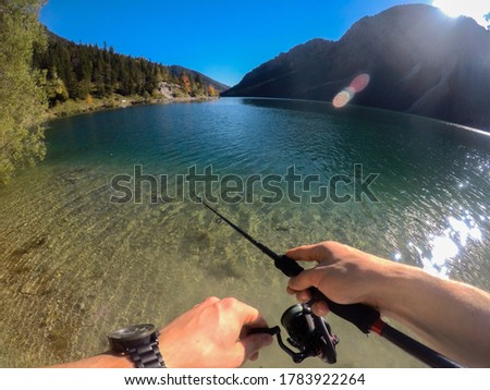 Fishing in a lake in Austria. Picture is token from the point of view of the fisher, showing the fishing rot.