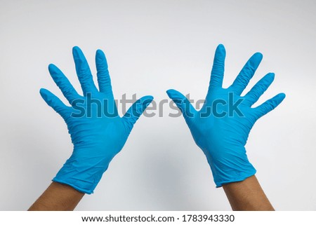 Woman hand wearing a blue rubber medical glove on white isolated background.