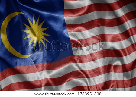waving colorful shining big national flag of malaysia on a silky texture