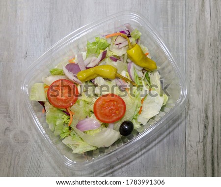 Top view of a prepackaged salad mix in a compostable container.