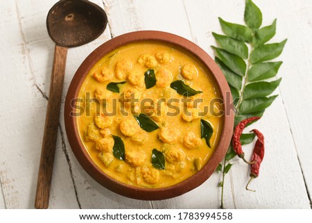 Kerala fish curry spicy Prawn mango curry recipe, Chemmeen Manga shrimp in coconut milk. white background South India. Top view popular Indian seafood, non veg food side dish for rice, appam