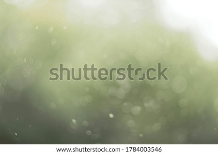 reflection of light on blurry drops of water on blurry desaturated background