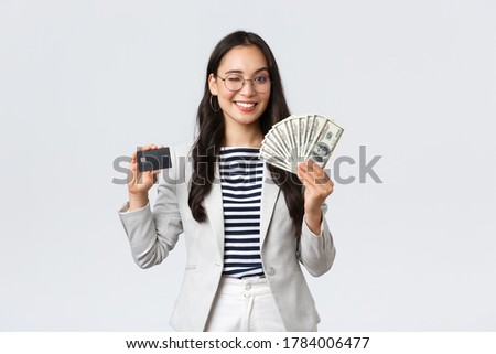 Business, finance and employment, entrepreneur and money concept. Successful asian businesswoman showing explain on courses how increase income, hold credit card and money, smiling camera