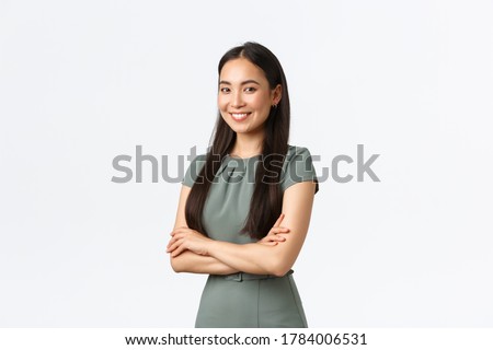 Small business owners, women entrepreneurs concept. Successful confident asian businesswoman in dress, cross arms and looking pleased at camera, smiling, managing store or internet site