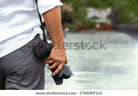 Man with photo camera Fashion Travel Lifestyle outdoor nature on sun light background.