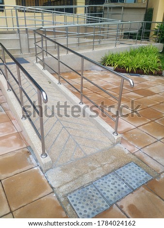 Entrance slope, ramp way to support wheelchair disabled people in front of the building.