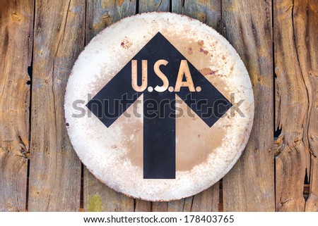 Vintage USA direction sign hanging on an old wooden wall