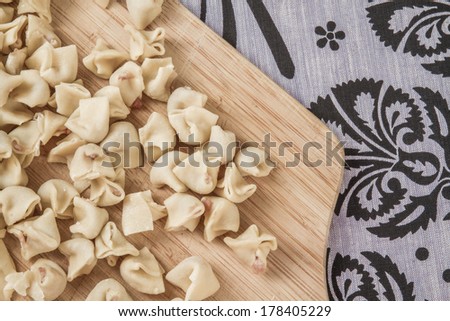 View of homemade raw ravioli on a wooden cutting board 