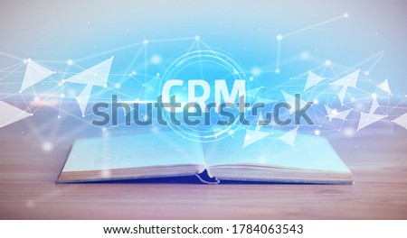 Open book with CRM abbreviation, modern technology concept
