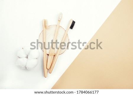 Three dental bamboo brushes on white background with flower of cotton
