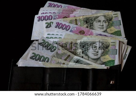 Czech money in a black wallet on a black background. Czech crowns.