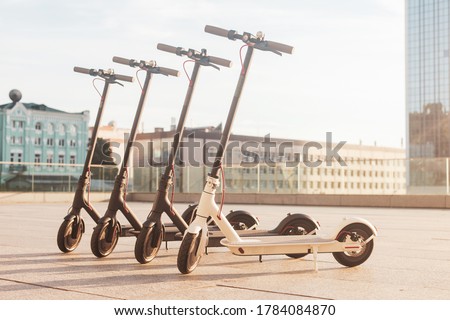 electric scooters stand on the street against the background of the city, transport of the future, eco transport rental Royalty-Free Stock Photo #1784084870
