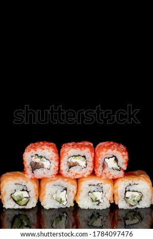Philadelphia roll with salmon, cheese and cucumber on a black background with reflection. Sushi Philadelphia.