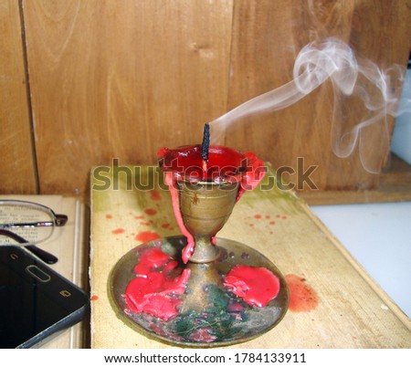 Smoked out candlestick on a book